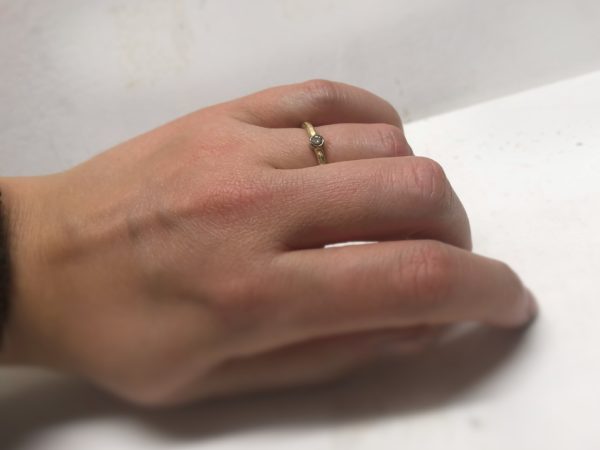 Eismatter Verlobungsring mit rundem Stein und glatter Fassung an der Hand Eirenie