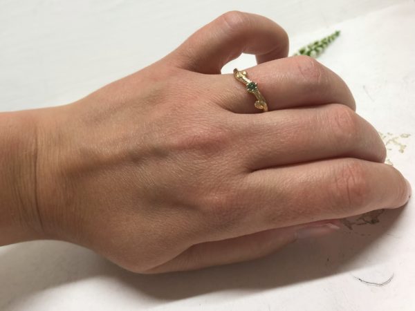 Natürlicher Verlobungsring mit grünem Stein Verdea an der Hand getragen