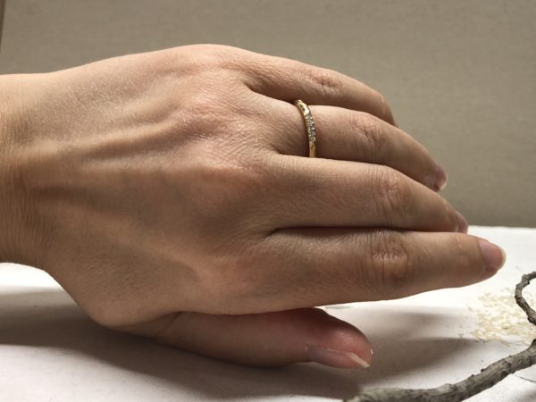 Handbild vom Memoire Ring mit Struktur und fünf Steinchen Fasetti 1