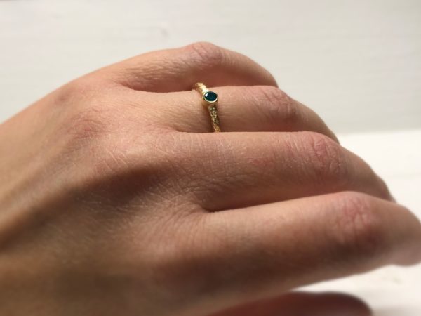 Verlobungsring mit blauem Stein Thetes an der Hand