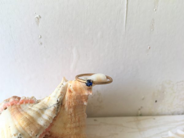 zarter verlobungsring mit blauem stein in krallenfassung