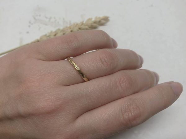 Schmaler Hammerschlagring aus Gold an der Hand Modell Aridene